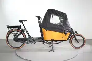 Zijaanzicht Vogue Carry 2 e-bakfiets met accu op de achterdrager en bruine bak
